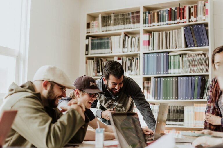 Grupo de personas trabajando juntas alrededor de una computadora portátil